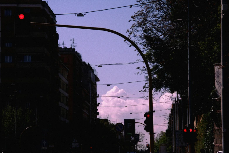 a tall building near some trees and traffic lights