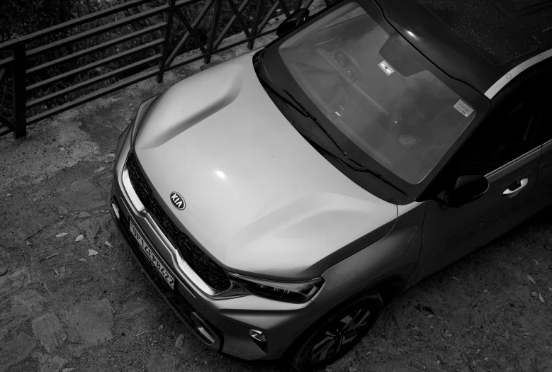 a silver car parked next to a fence