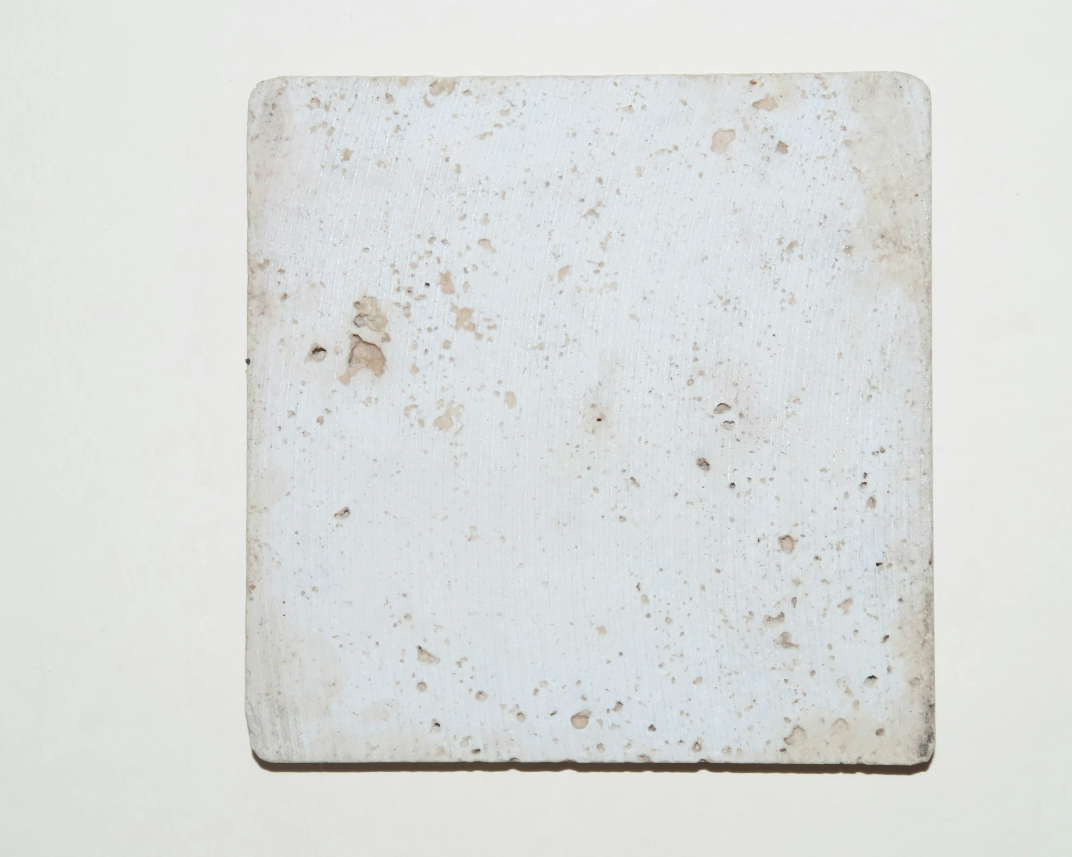 a piece of white tile sitting on top of a counter