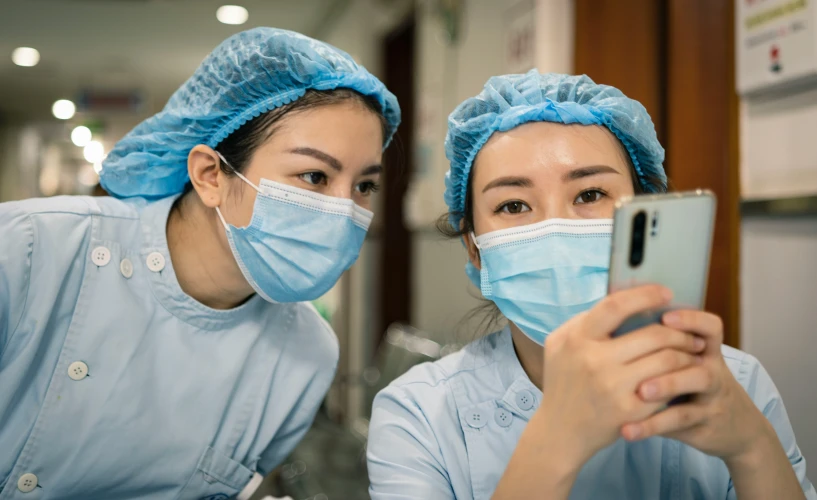 two asian nurses take a po with their cell phone
