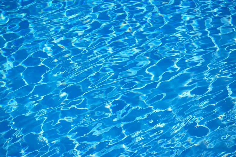 the bottom half of a swimming pool with blue water