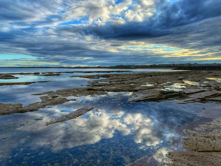 some water clouds and rocks and a body of water