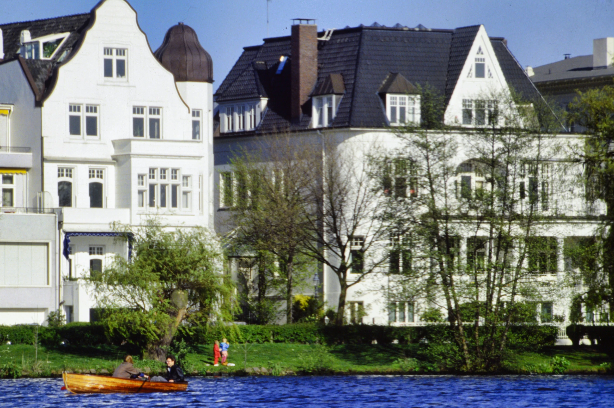 two people in the distance in a small boat near buildings