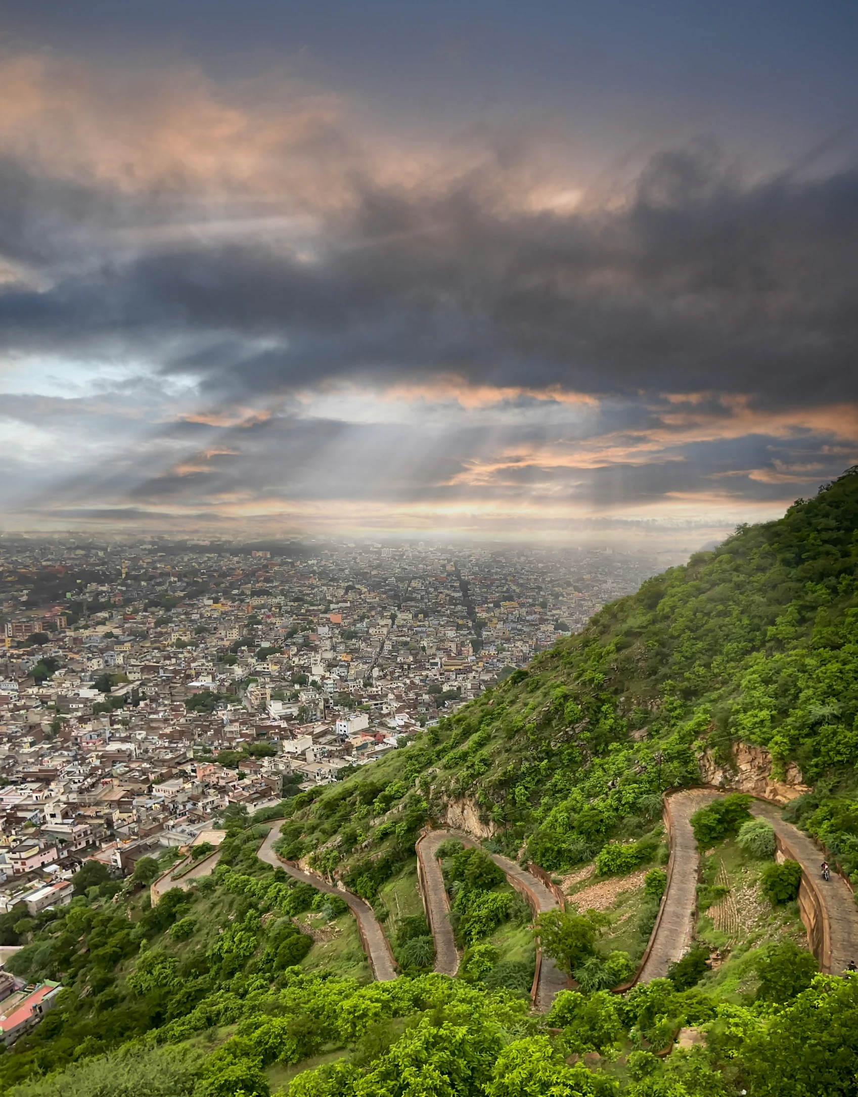 a scenic view of a town and a valley from the top of a hill