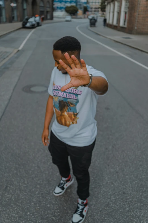 a man walking on the street while holding his hand out to someone