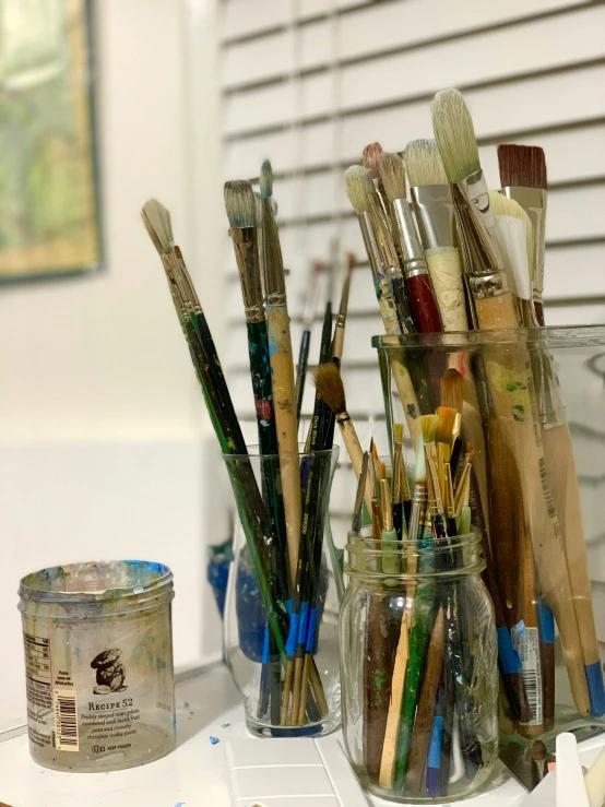 some brushes are on the table and are in the jars