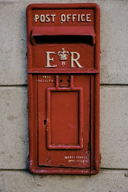 the wall is concrete and has a sign reading post office