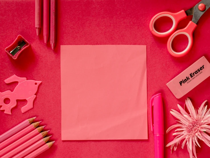 pink crayons, pens, scissors, eraser, and other items on a pink table