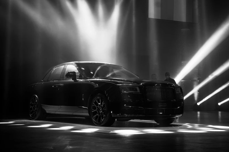 a rolls royce parked in a dimly lit stage