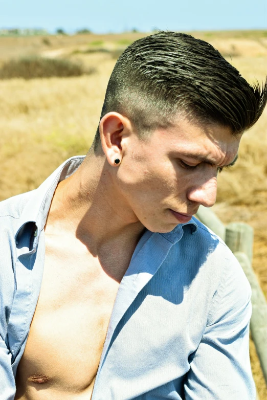 a male with a shaved back wearing a blue shirt