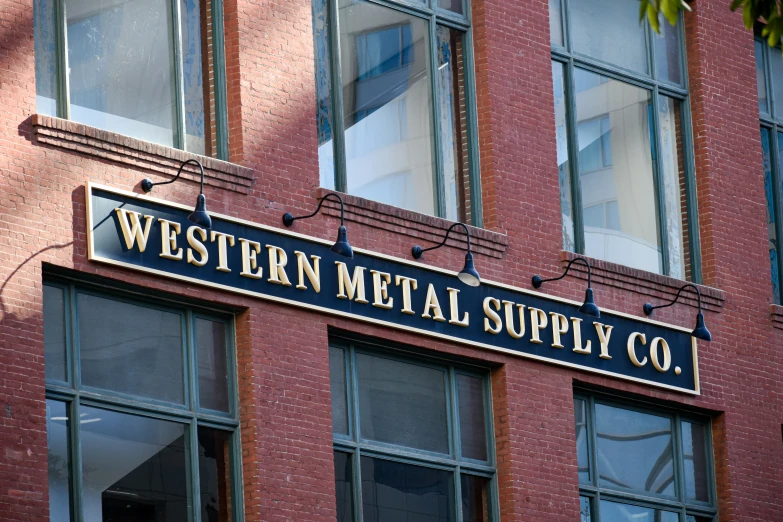 a metal and wood store sign in front of a brick building