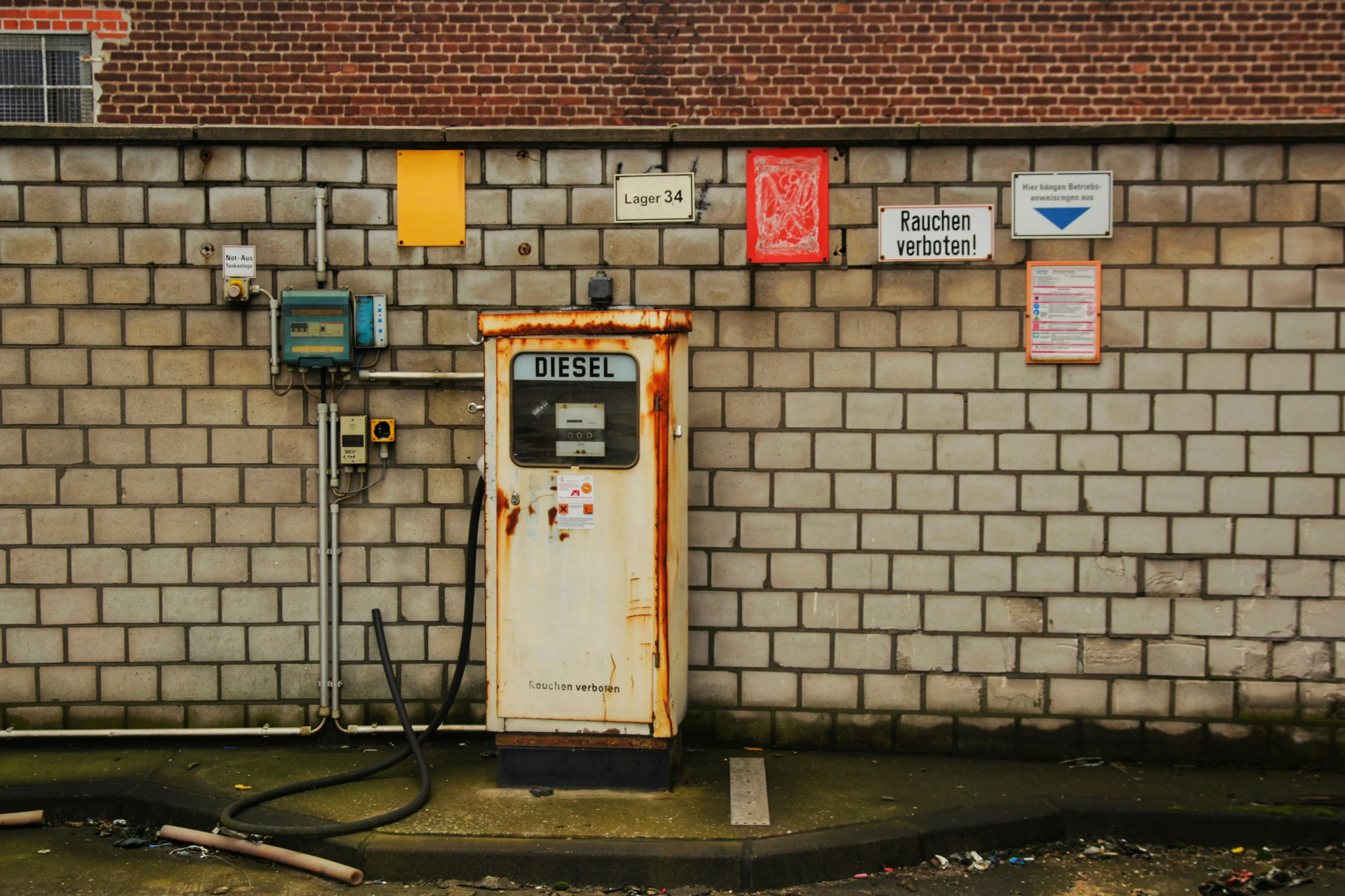 an old rusted gas pump is sitting next to a wall