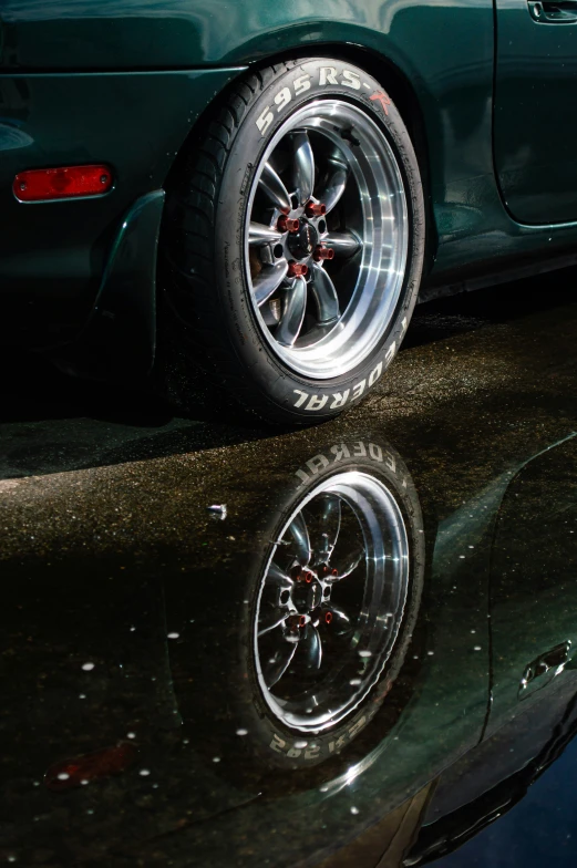 a car has been pographed in reflective reflection on a dark surface