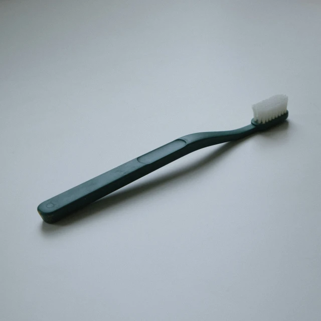 a black and white image of a toothbrush sitting on a table