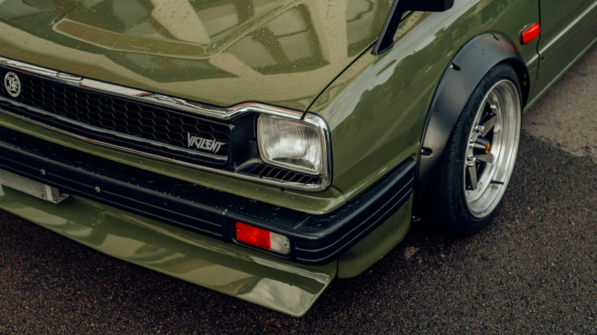 there is a green camo car parked in front of a red car