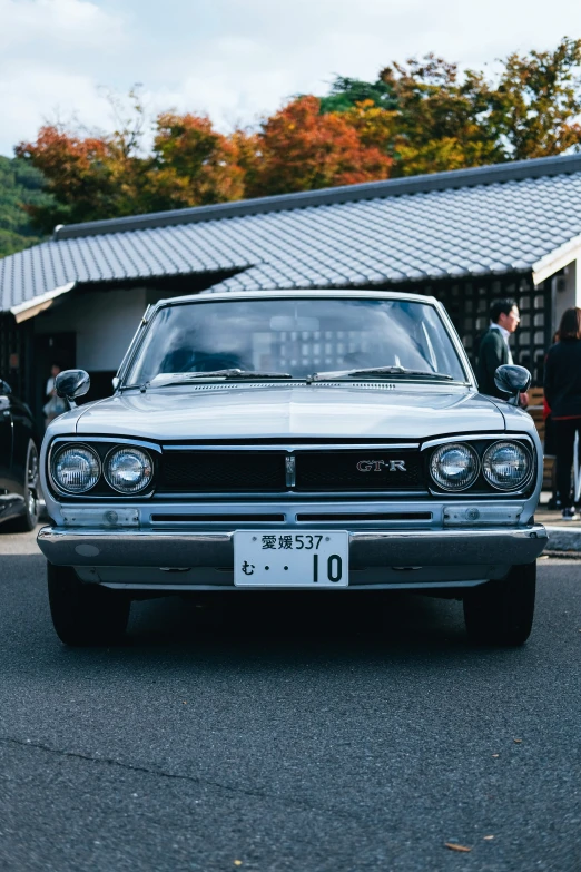 a old car is parked in front of a group of people