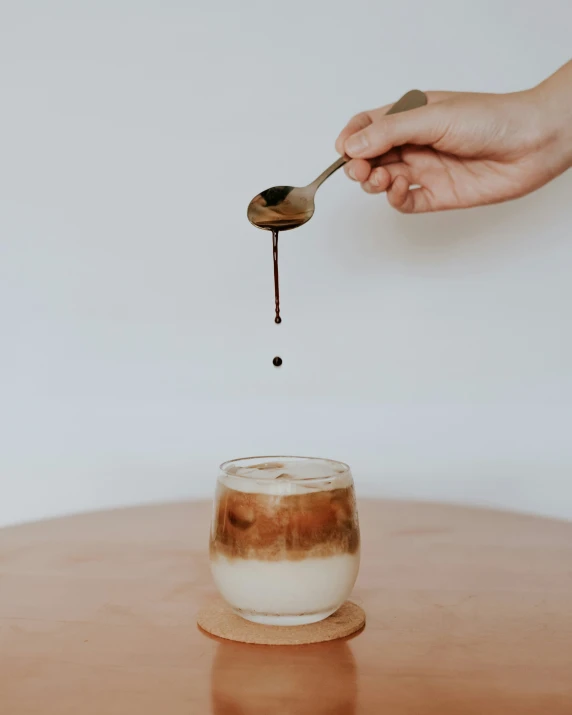 a hand is sprinkling chocolate into a glass