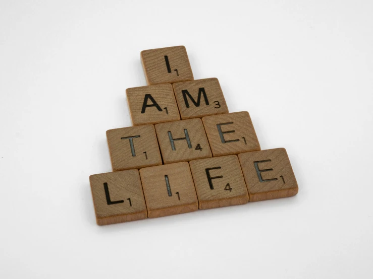 a scrabble type word on wood blocks in the shape of a christmas tree