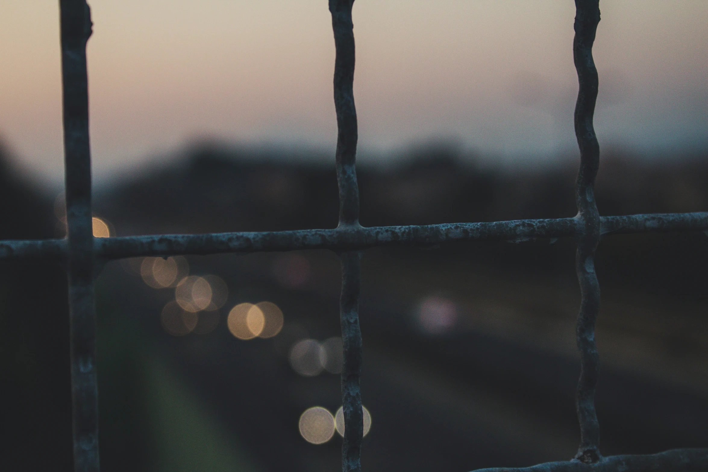 a blurry view of the outdoors through a fence