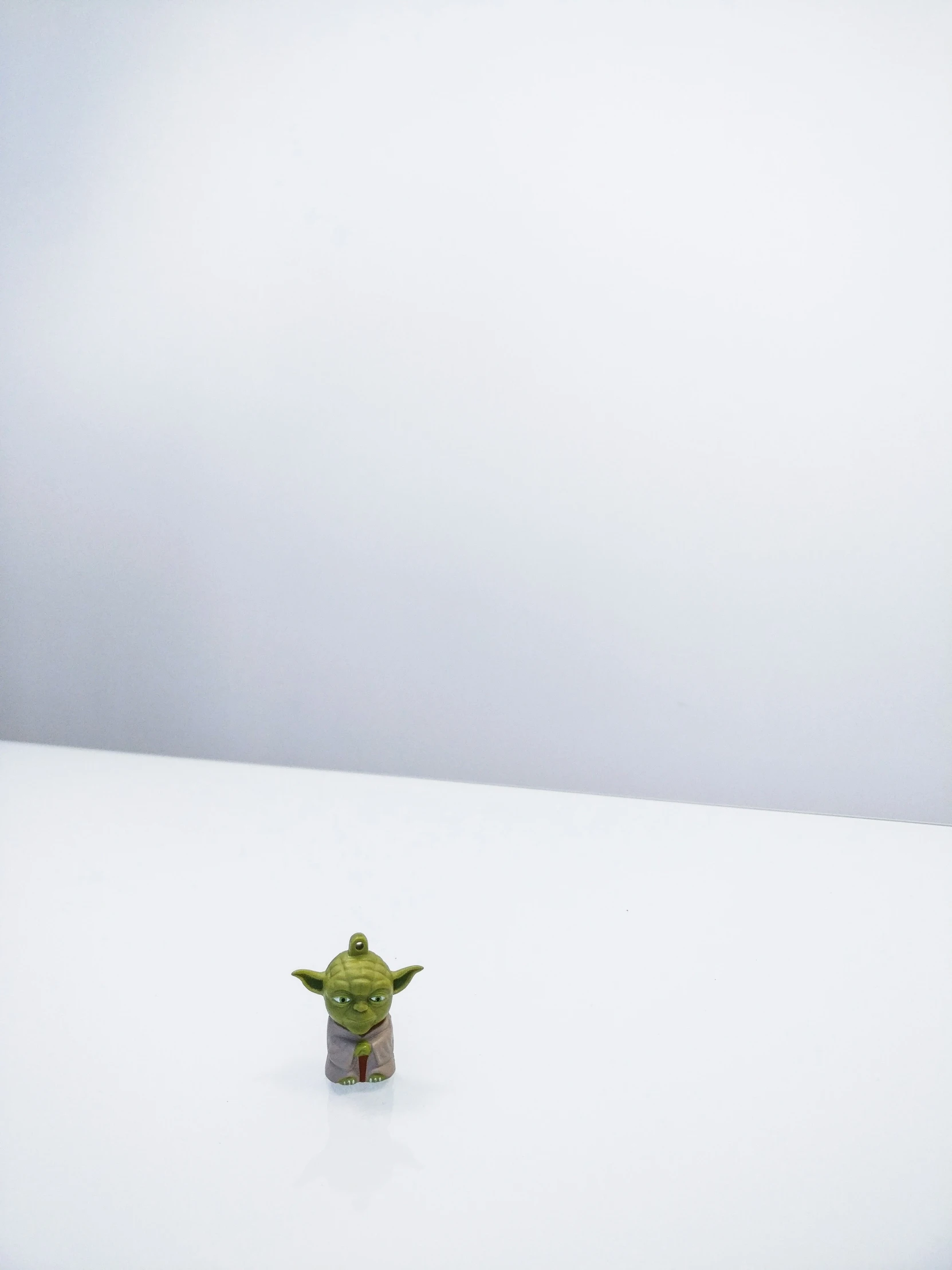 a small green toy is sitting on a white surface