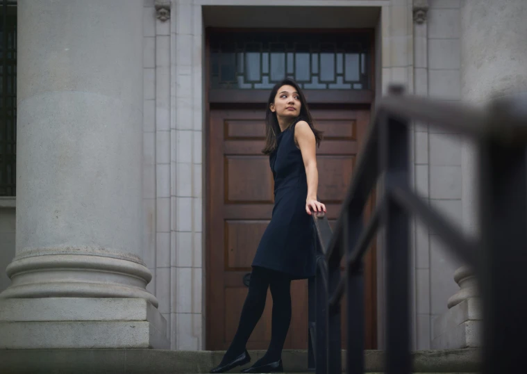 a woman walking up stairs next to a door