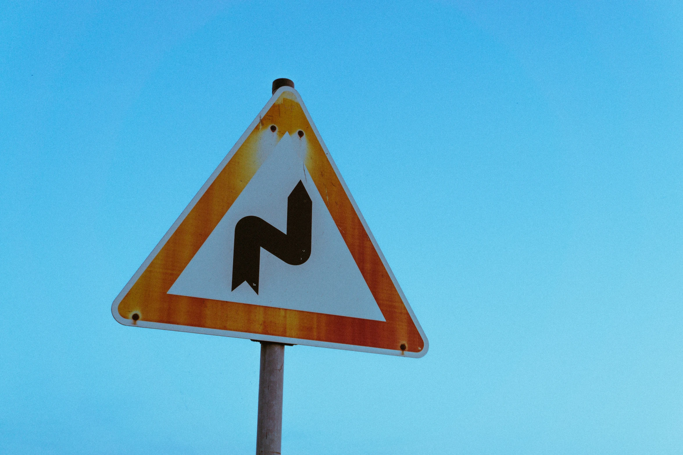 a sign is displayed in front of the clear blue sky