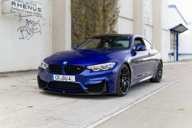 a blue sports car in front of a building