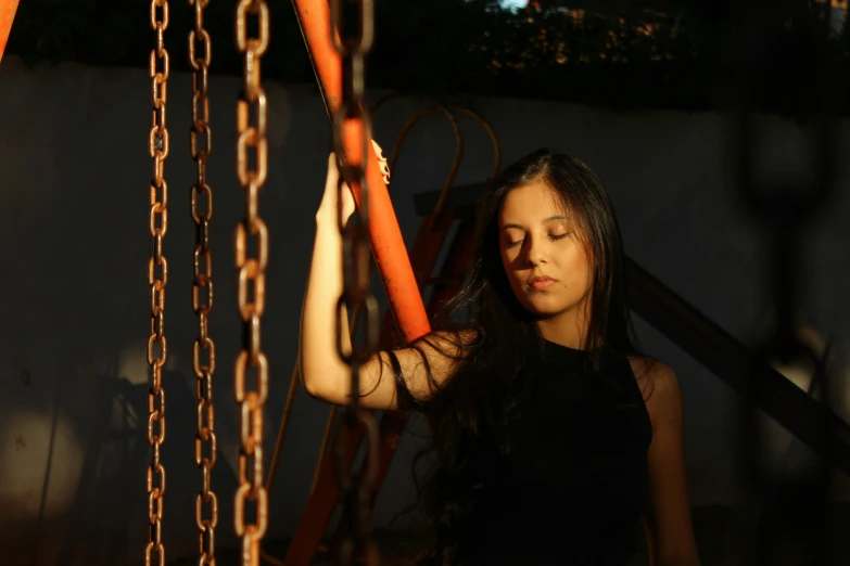 a woman hangs out her clothes in front of metal chains
