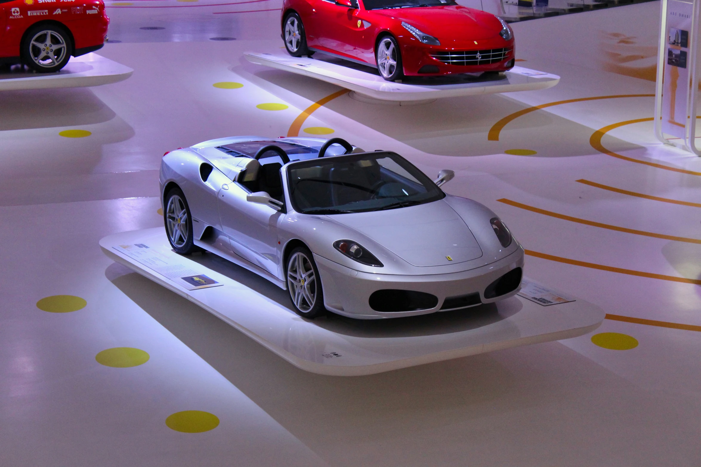 many different colored sports cars on display in a showroom