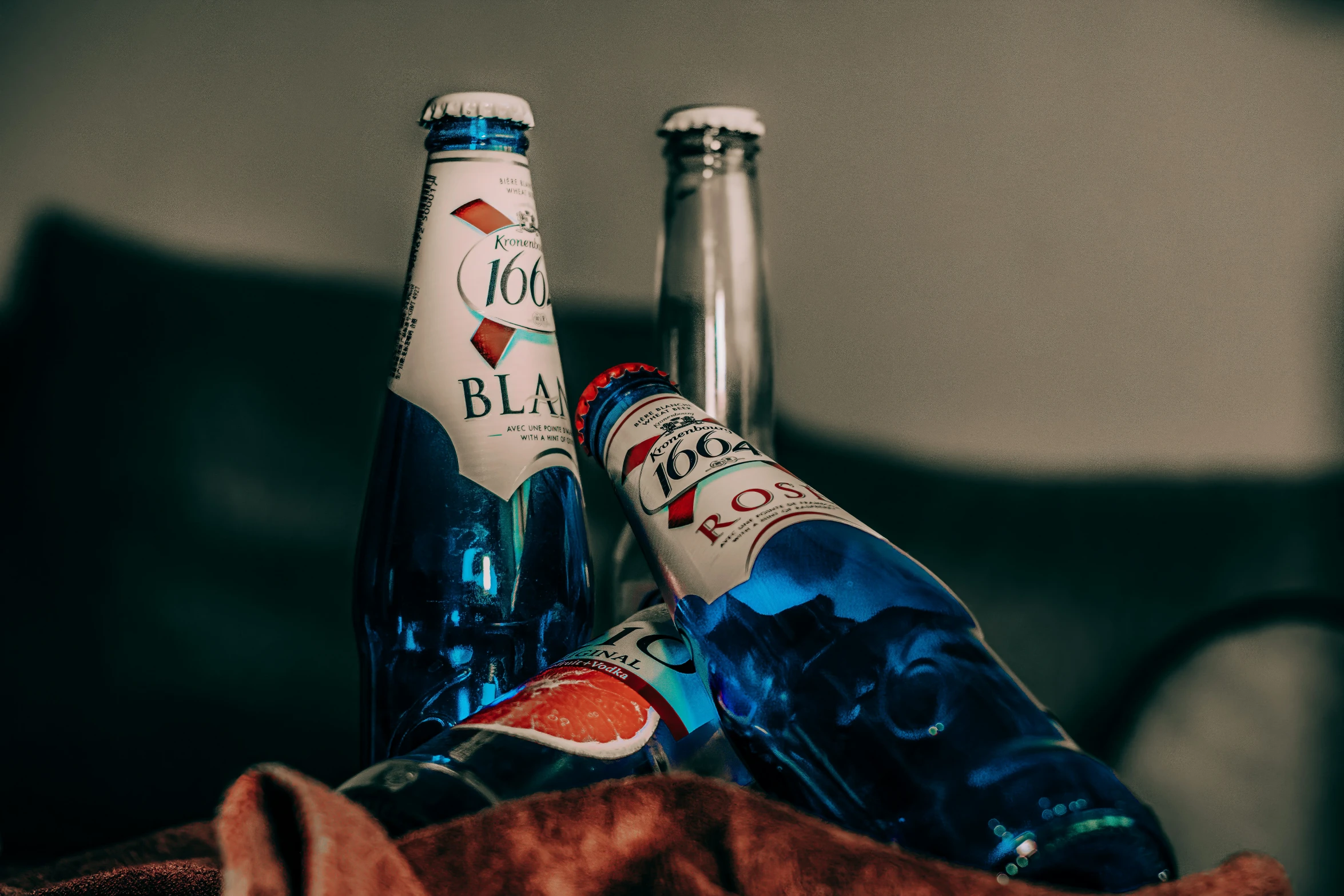 two bottles of alcohol sit side by side on a sofa