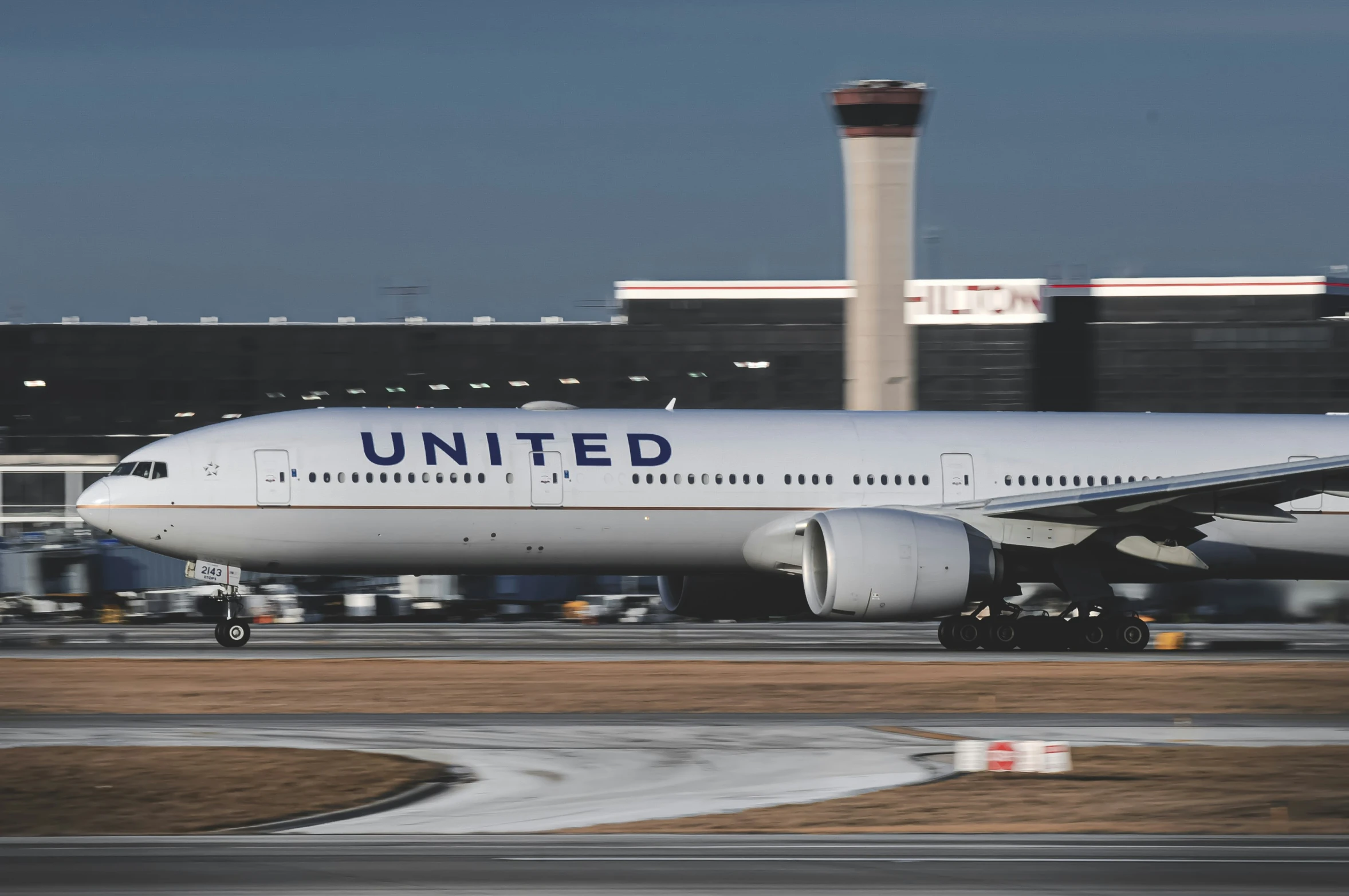 an airplane sitting on a runway with a few buildings in the background