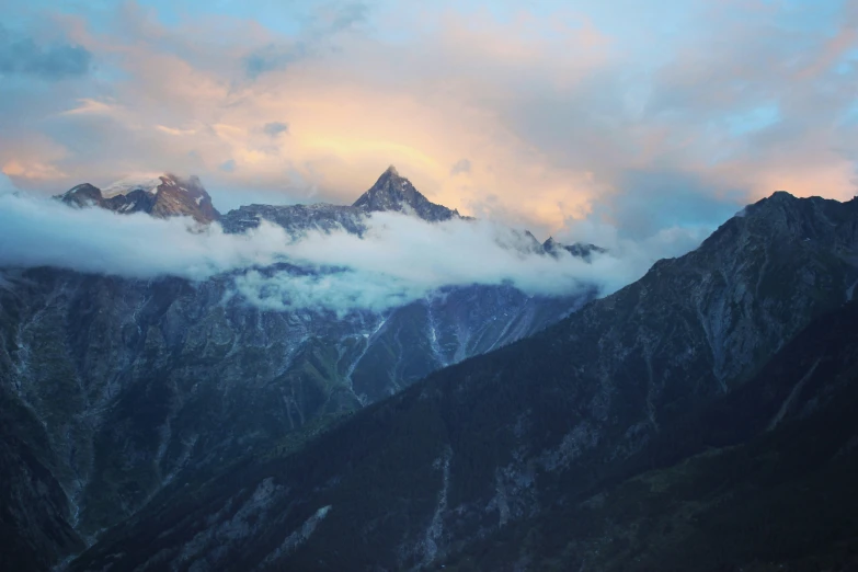 the mountains below are covered in low clouds