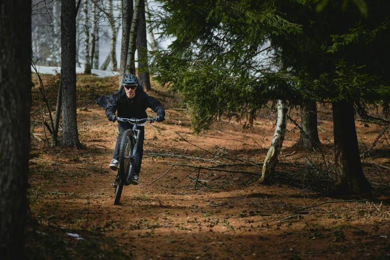 a man riding on a bike in the woods