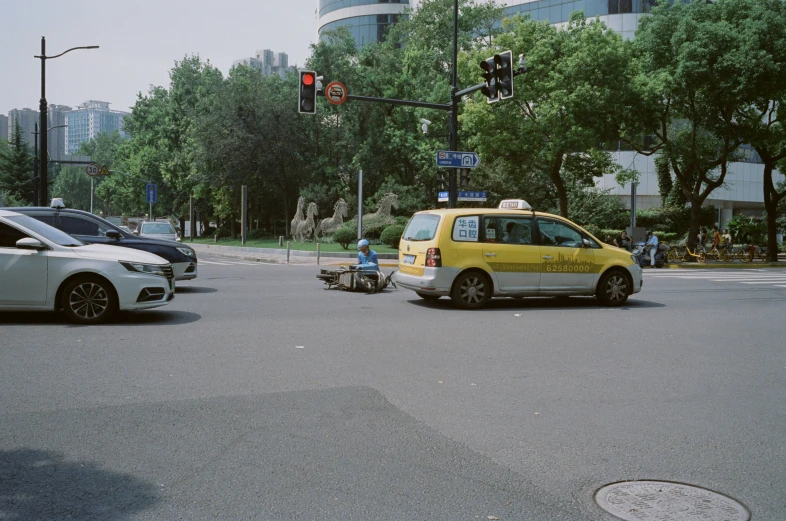 an intersection with a taxi cab and people on a small cart