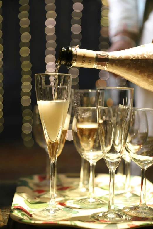 a table with champagne being poured into wine glasses