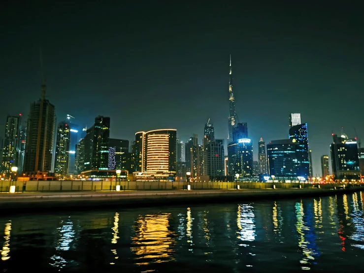 a night scene with buildings along the water