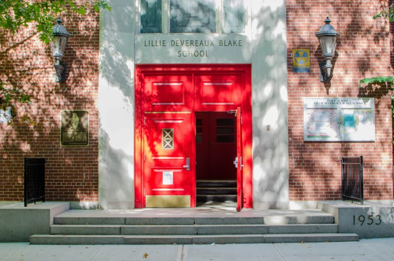 a bright red door is open outside of a brick building