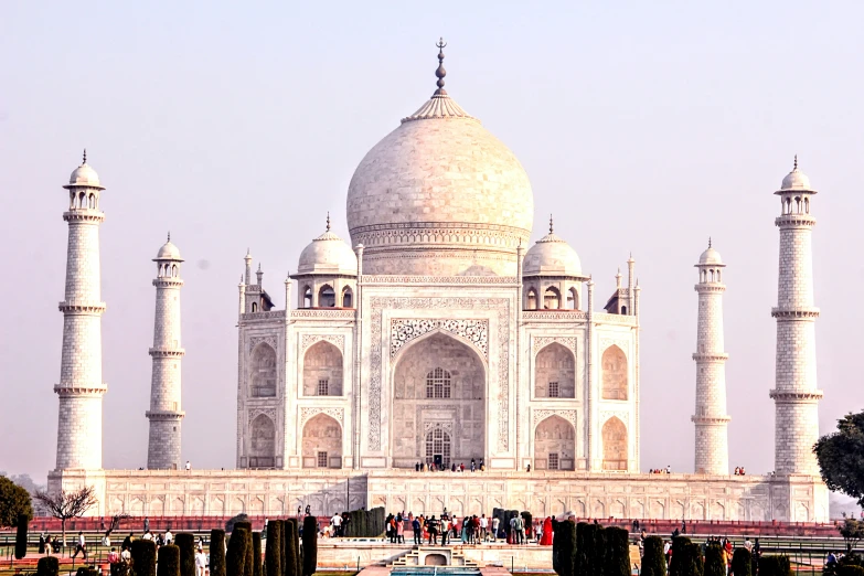 a large stone building that has two towers and many people