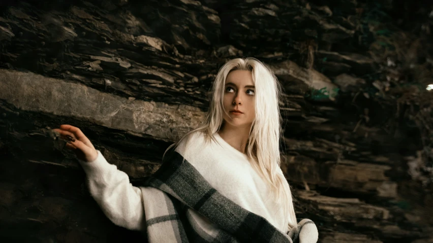 woman in white and black knit jacket next to tree