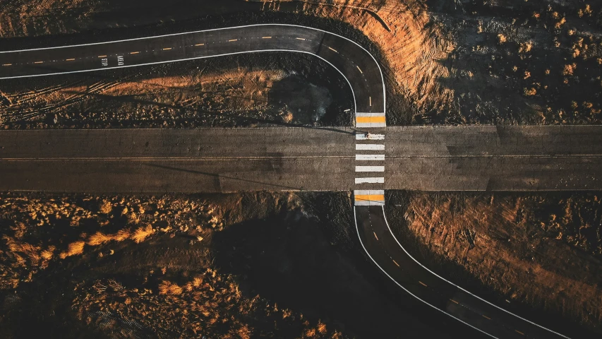 aerial pograph of a road winding in on one side