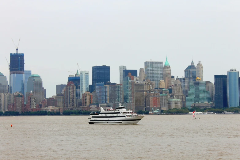 a large boat is out on the ocean in front of a very high rise