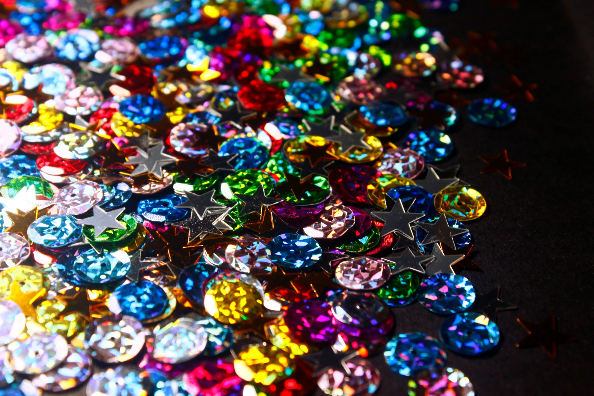 several multicolored, star shaped jewels scattered on top of each other