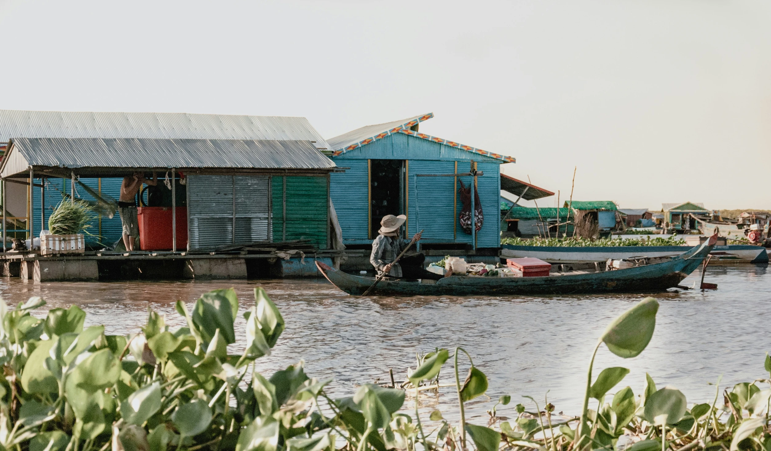 an old boat with a shack on the water