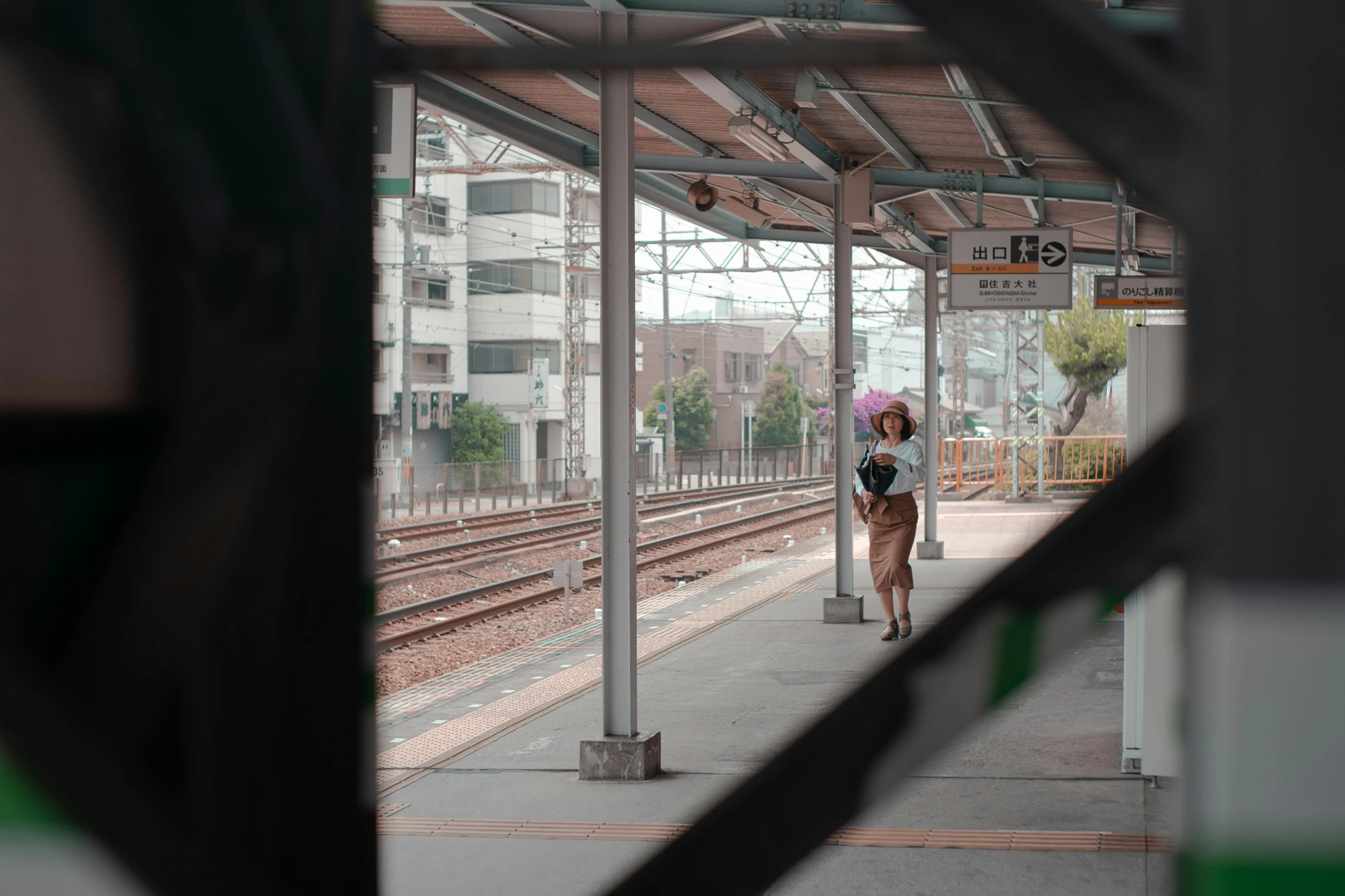 woman walking with umbrella on the platform of a train station