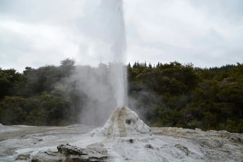 geysers pouring out from top of rock in foreground