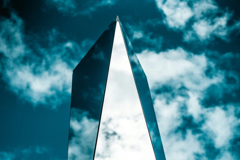 tall monument standing in front of clouds and blue sky
