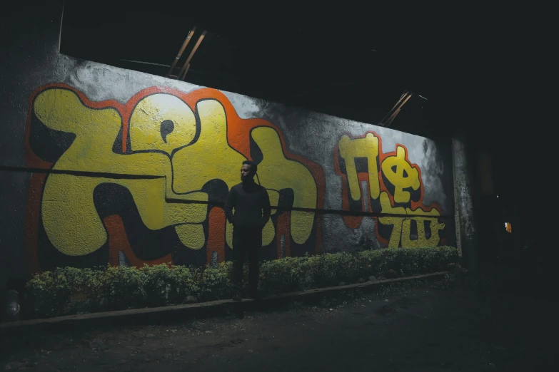 two men standing in front of a graffitti wall