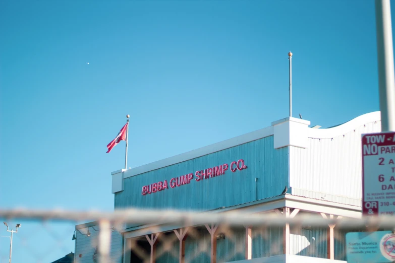 a tall building has a red sign and a flag