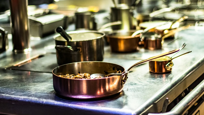 a stainless steel table topped with pots and pans