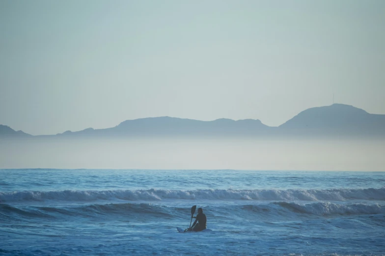 two people in the ocean are standing on surf boards